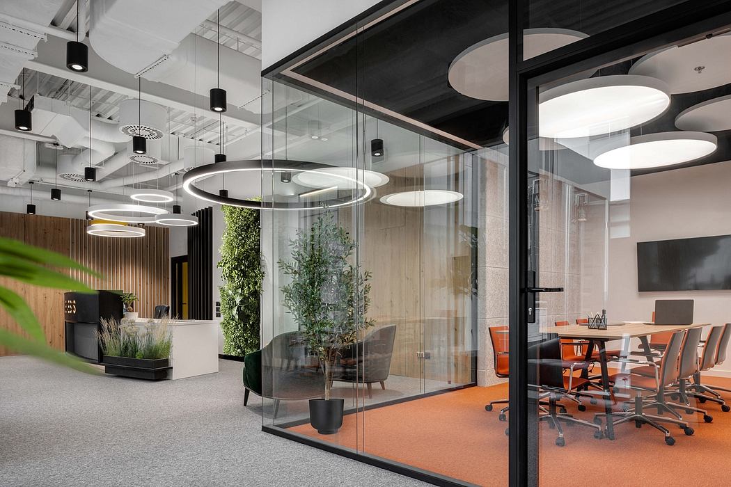 Modern office space with glass walls, circular lighting fixtures, and natural elements.