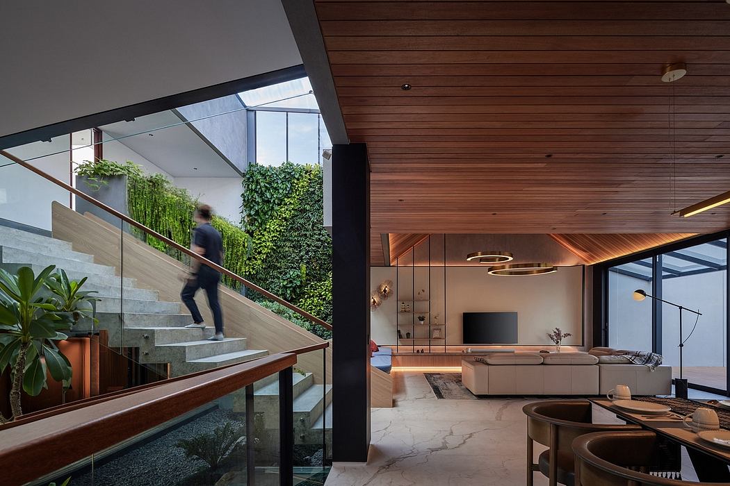 A modern interior with wooden paneling, glass walls, and a lush greenery backdrop.