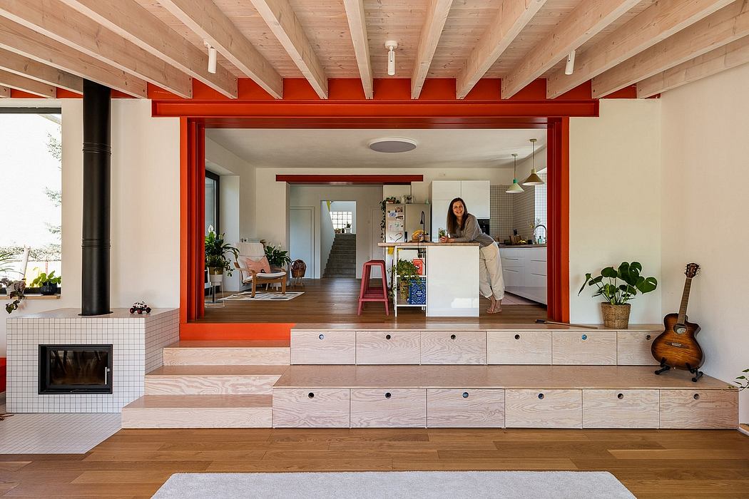 Warm, modern interior with wooden beams, red accents, and multi-level living spaces.