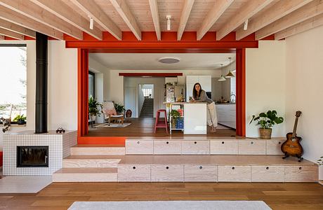 Warm, modern interior with wooden beams, red accents, and multi-level living spaces.