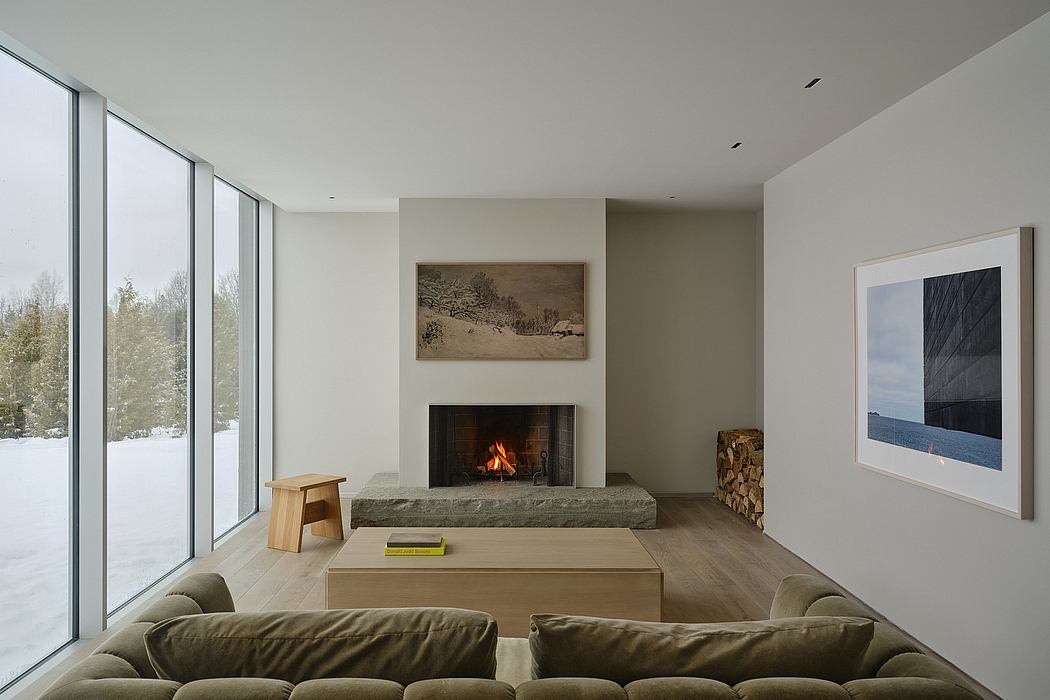 Spacious living area with large windows, fireplace, and minimalist furniture.