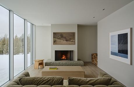 Spacious living area with large windows, fireplace, and minimalist furniture.