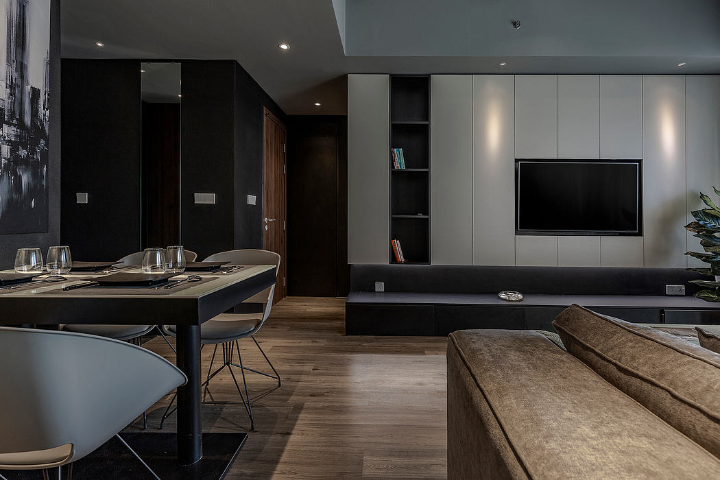 Sleek, modern interior with dark accents, built-in cabinetry, and a large TV mounted on the wall.