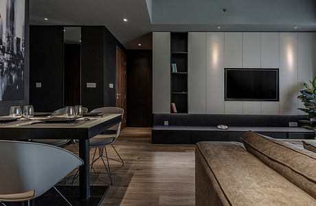 Sleek, modern interior with dark accents, built-in cabinetry, and a large TV mounted on the wall.