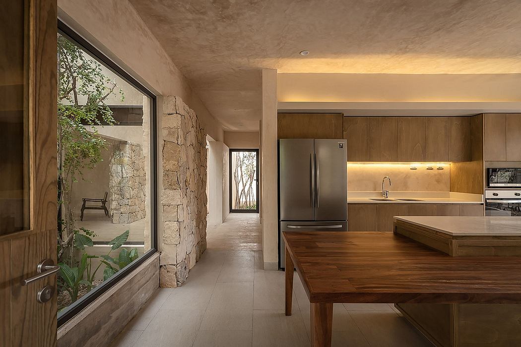 A modern, open-concept kitchen and dining area with rustic stone walls and wooden accents.