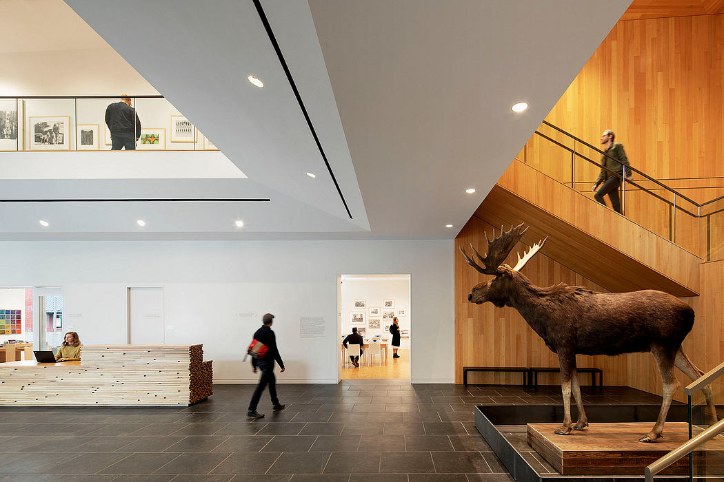 Spacious modern lobby with wooden paneling, artwork, and a mounted moose sculpture.