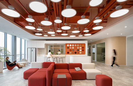 Cozy office with vibrant red sofas, creative lighting fixtures, and minimalist design.