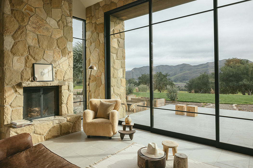 Cozy stone-walled living room with floor-to-ceiling windows offering mountain views.