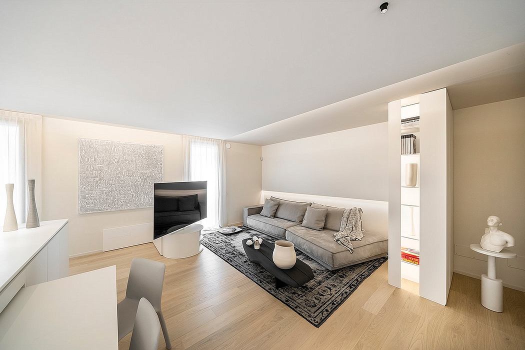 Minimalist living room with grey sofa, black coffee table, and modern wall decor.