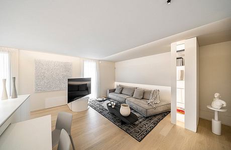 Minimalist living room with grey sofa, black coffee table, and modern wall decor.