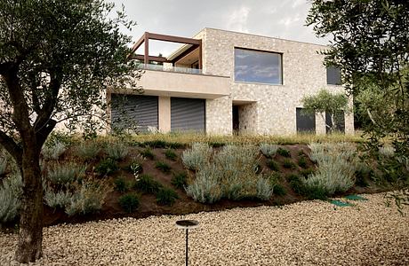 A modern two-story home with a stone exterior, balcony, and lush landscaping.