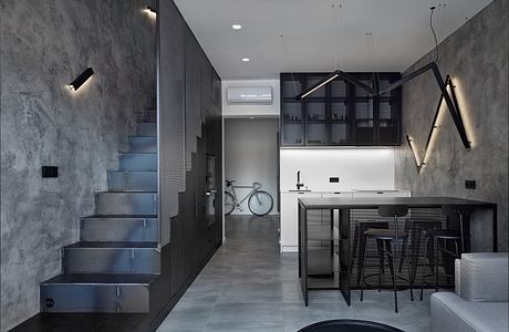 Minimalist apartment interior with steel staircase, industrial-style kitchen, and muted tones.