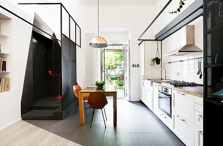 Modernist kitchen with open layout, glass partitions, and natural light from outdoor view.