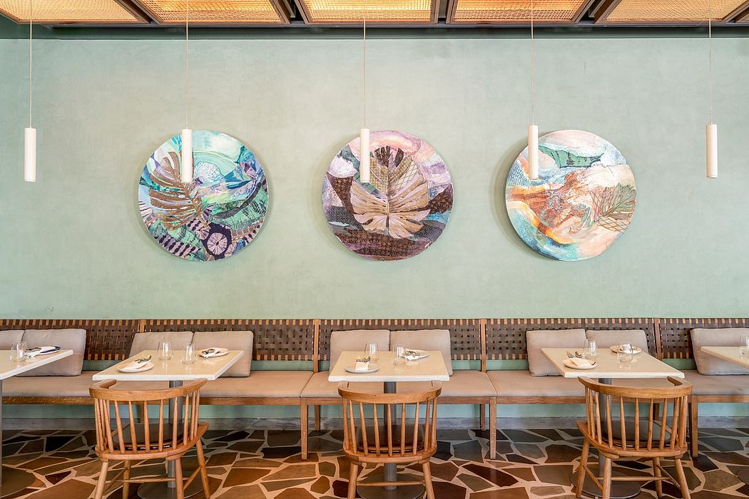 A modern restaurant interior with wooden tables, chairs, and colorful circular wall decor.