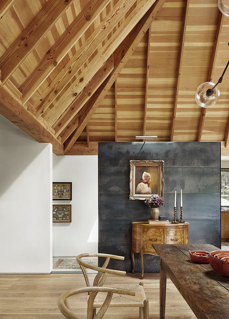 Rustic wooden beamed ceiling, vintage furnishings, and painted artwork create a cozy, welcoming interior.