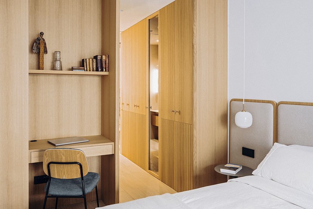 Modern, wood-paneled bedroom with built-in storage, desk, and minimalist decor.