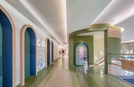 A modern, colorful hallway with arched doorways and geometric design elements.