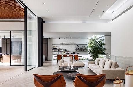 Spacious, minimalist living room with wooden and glass elements, built-in shelves.