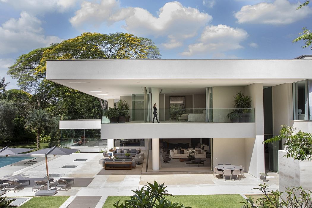 Sleek, modern architecture with expansive glass walls, open floor plan, and lush landscaping.