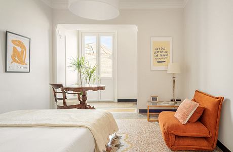 Cozy bedroom with warm color palette, modern furniture, and Matisse-inspired art.