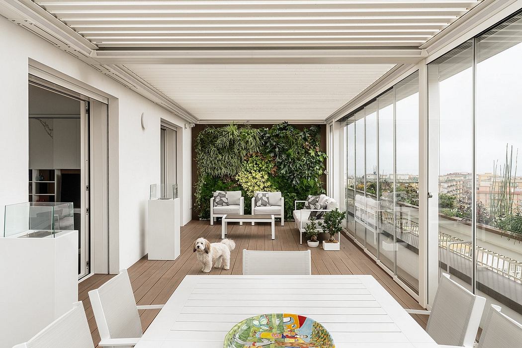 A bright and modern balcony with lush vertical garden, large windows, and cozy seating.