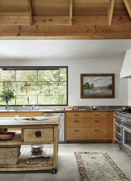 Rustic wooden beams, large windows, warm tones, and a mix of modern and vintage decor.