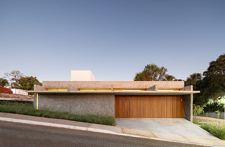 A modern concrete and wood structure with overhead canopy and integrated lighting.