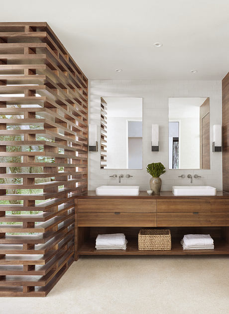 A modern bathroom with a unique wooden slat wall, dual sinks, and ample storage.