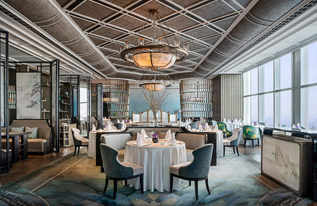 Ornate ceiling with intricate wooden pattern and elegant chandelier in a luxurious dining area.