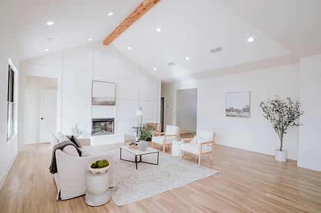 Bright, airy living room with vaulted ceilings, wood beams, and minimalist furniture.