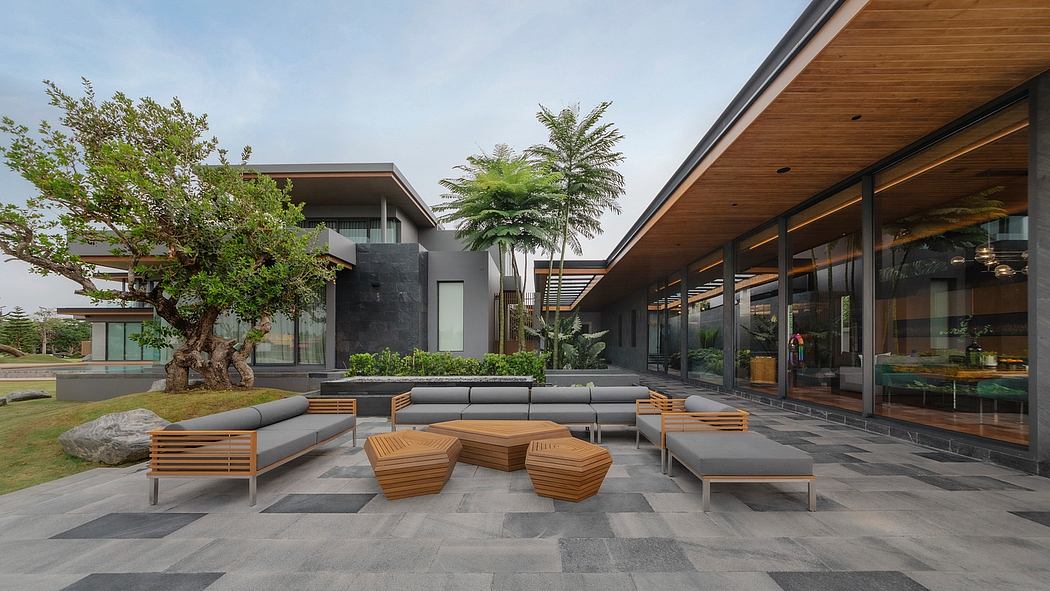 Contemporary outdoor lounge area with wooden benches, planters, and glass walls.