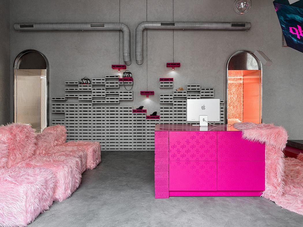 A modern, minimalist interior with bold pink furniture, industrial pipes, and concrete walls.