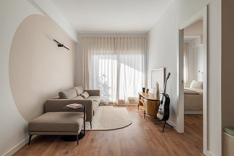 Spacious apartment with minimalist decor, neutral tones, and wood flooring.