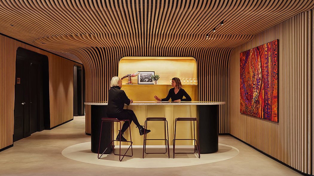 A modern, minimalist reception area with curved wooden wall panels and a sleek counter.