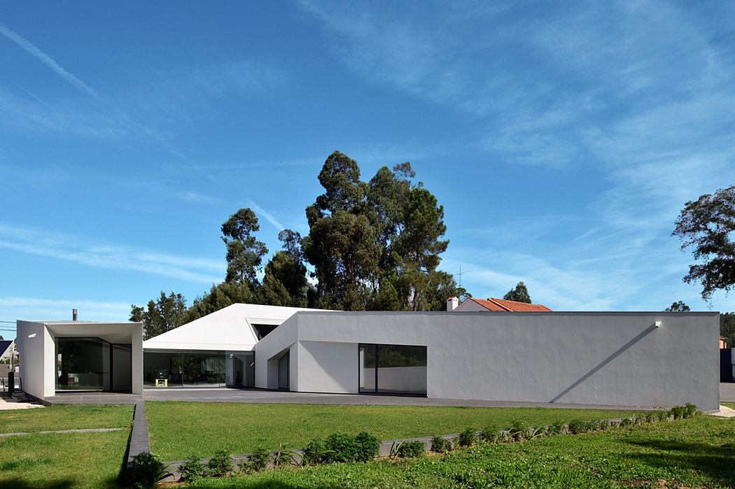 A modern, minimalist architectural design with clean lines, large windows, and lush surroundings.