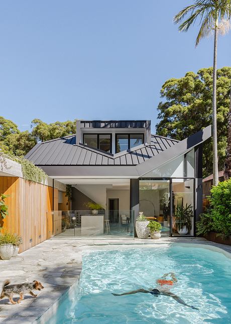 Modern home with sleek architectural design, open glass walls, and an inviting pool.