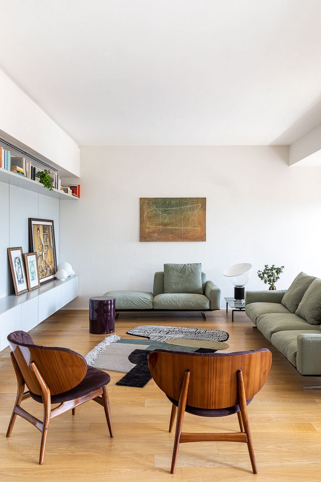 Minimalist living room with clean lines, plush green sofa, and mid-century wooden furniture.