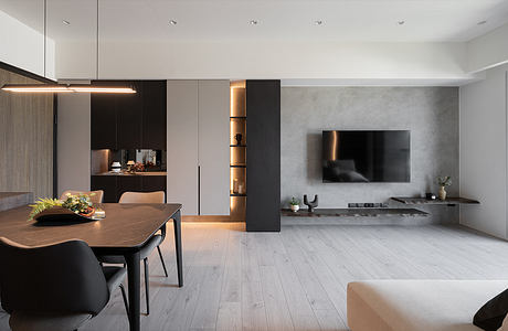 A modern, minimalist interior with warm lighting, wooden furniture, and a sleek TV setup.