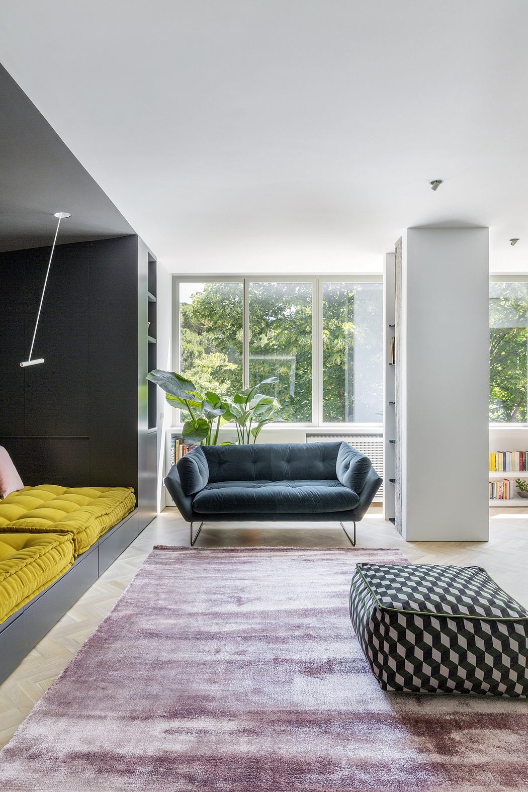 Large windows, sleek black and white furniture, pops of yellow and geometric accents.