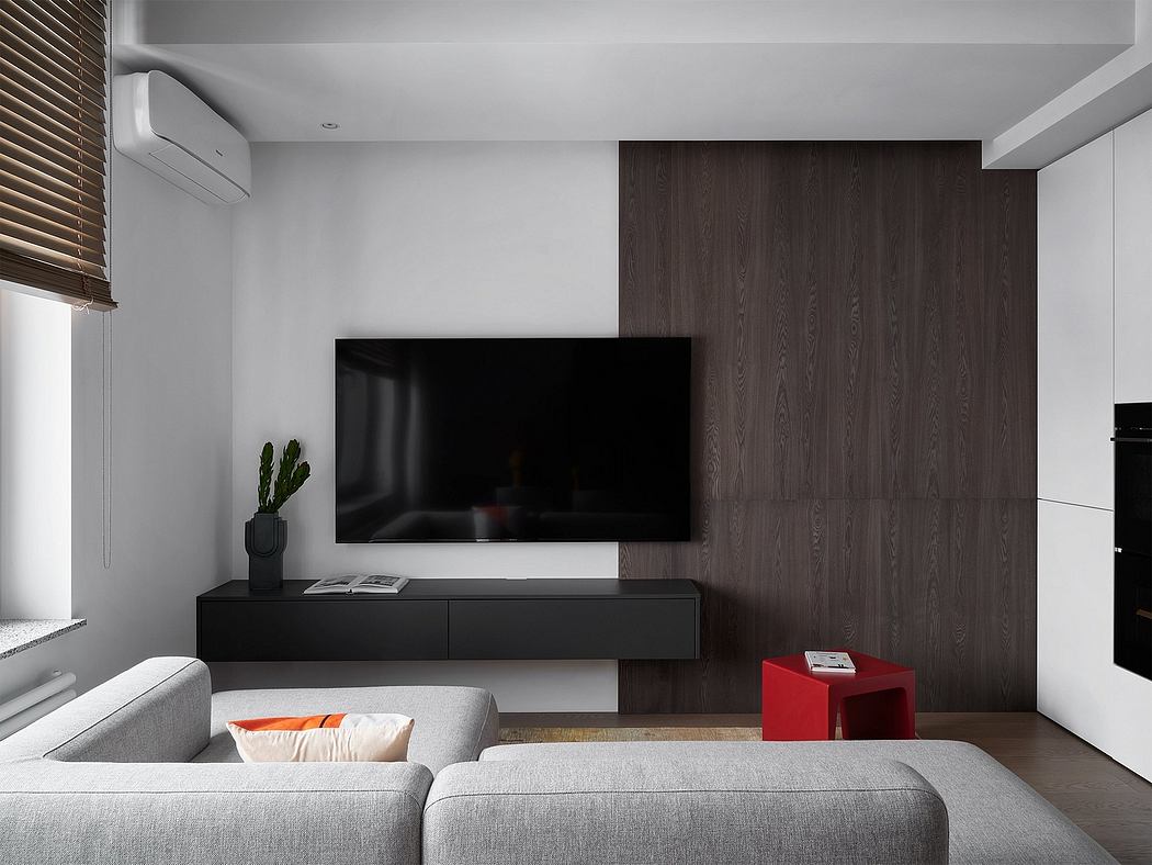 A modern living room with a large TV, dark wood panels, and a gray couch.