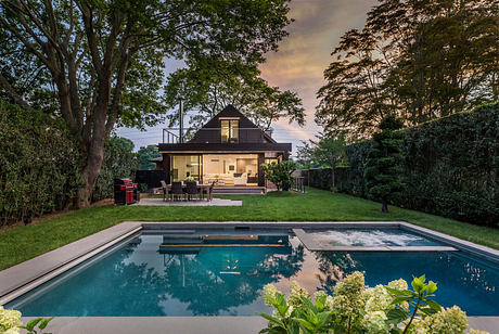 Cozy modern home with sleek pool, lush greenery, and warm outdoor living space.