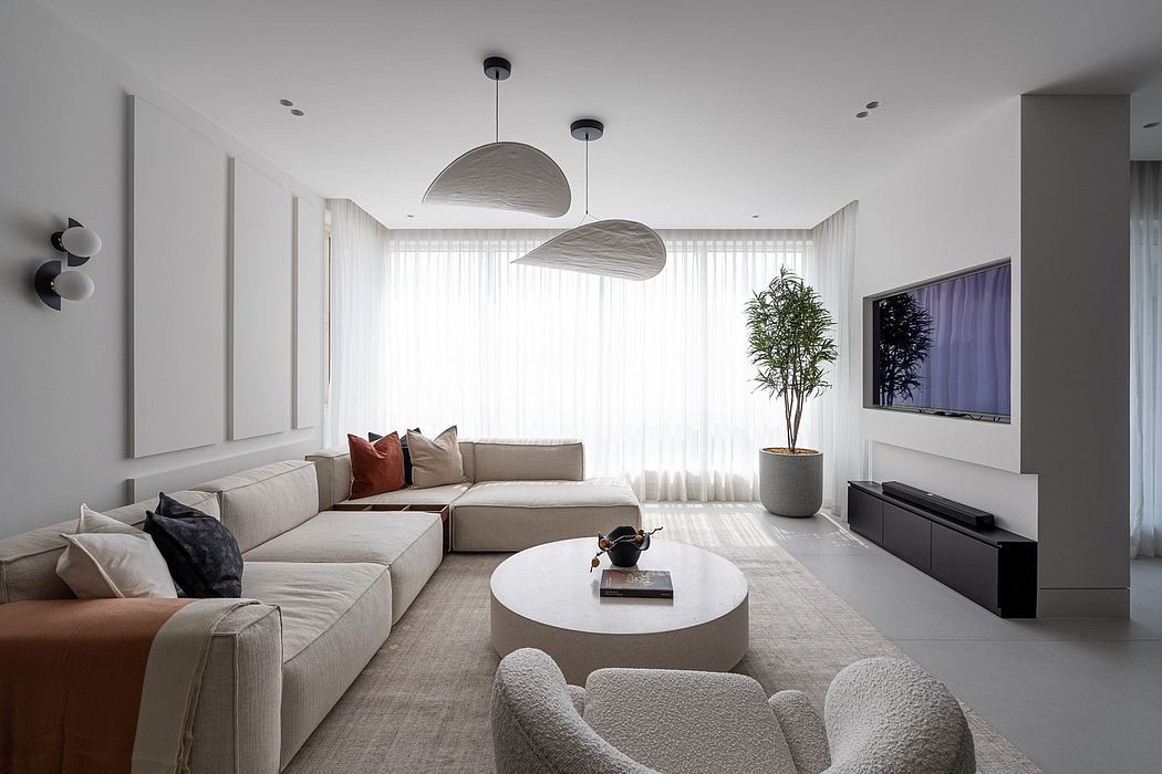 Spacious, modern living room with sleek furniture, minimalist decor, and pendant lights.