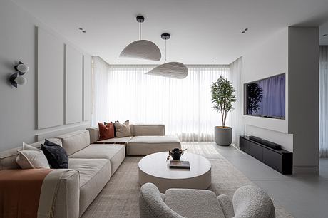 Spacious, modern living room with sleek furniture, minimalist decor, and pendant lights.