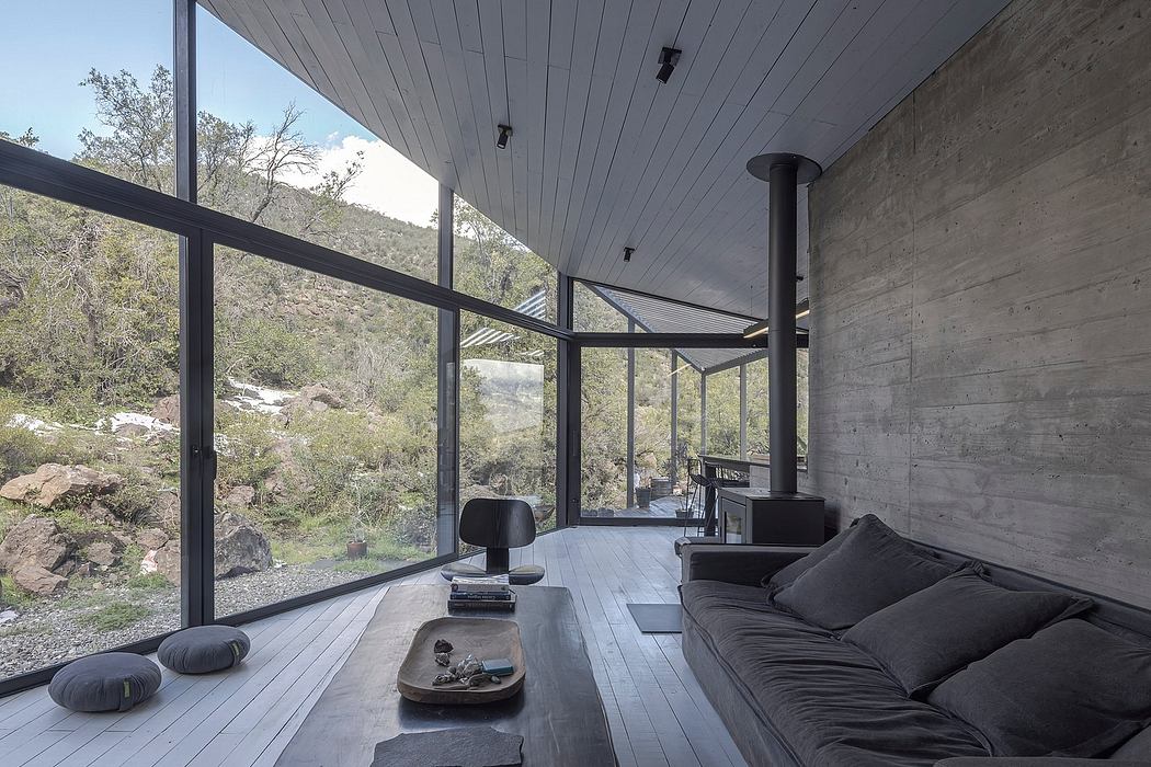 Sleek modern interior with concrete walls, large windows, and dark wooden floors.