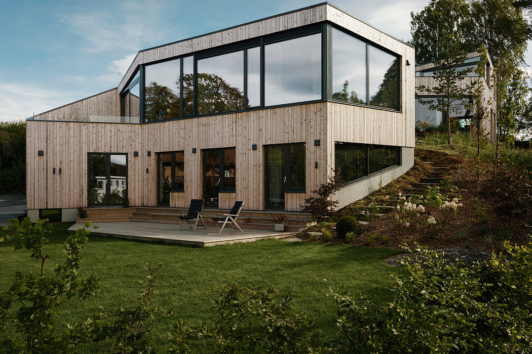Modern wooden and glass exterior with a spacious deck and lush garden surroundings.
