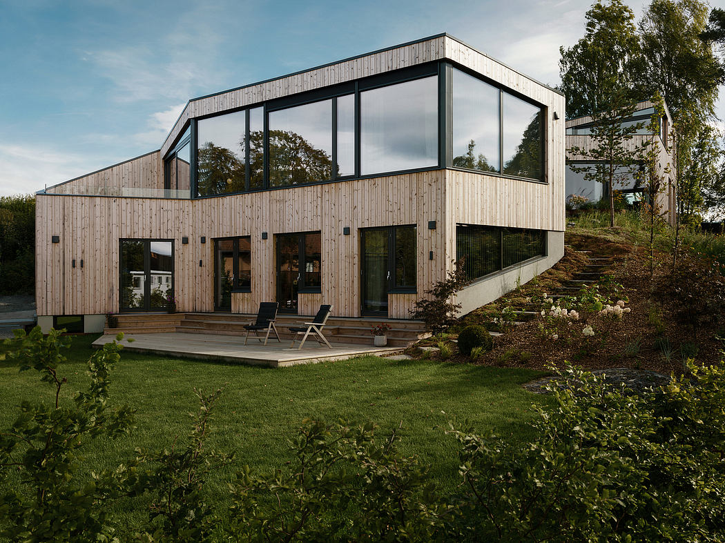 Modern wooden and glass exterior with a spacious deck and lush garden surroundings.