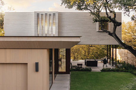 A contemporary house with clean lines, large windows, and a covered outdoor seating area.