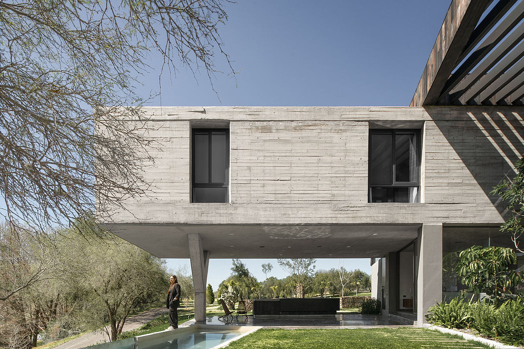 Sleek, modern concrete architecture with cantilevered roof, surrounded by lush greenery.