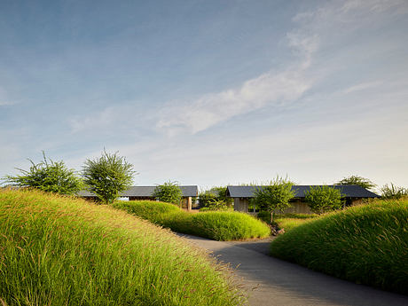 A scenic rural landscape with several modern, dark-colored structures nestled amid lush greenery.