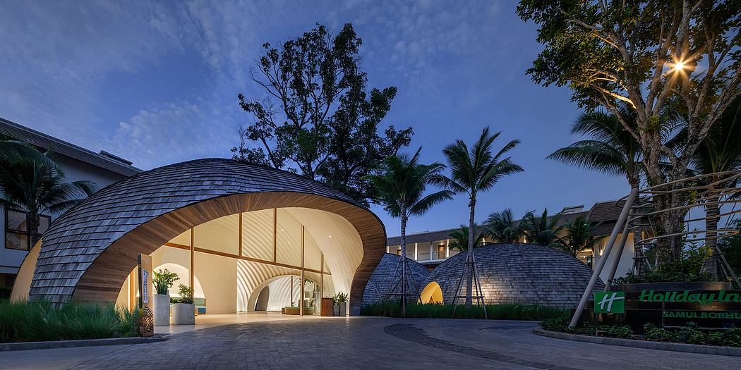A stunning, modern lobby with curved wooden structures, palm trees, and a night sky backdrop.